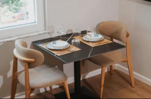 a dining room table with two chairs and a black table at Shehu Skenderbeg Stay in Tirana +9 photos