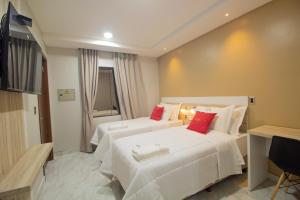 a hotel room with two beds with red pillows at Los Olivos Hotel in San Estanislao +39 photos