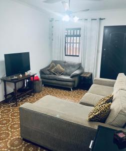 a living room with a couch and a chair at Casa na Ponta da Praia - Quintais privativos, churrasqueira e Wi-fi - Até 6 hospedes in Santos