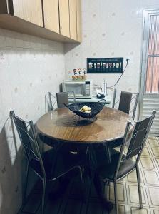 a kitchen with a wooden table with chairs and a tableasteryasteryasteryasteryastery at Casa na Ponta da Praia - Quintais privativos, churrasqueira e Wi-fi - Até 6 hospedes in Santos +10 photos