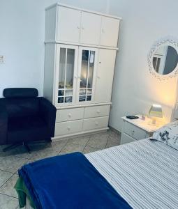 a bedroom with a bed and a dresser and a chair at Casa na Ponta da Praia - Quintais privativos, churrasqueira e Wi-fi - Até 6 hospedes in Santos
