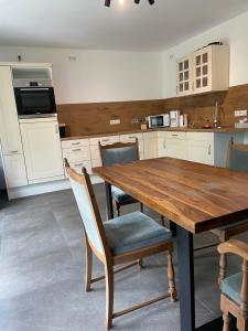 a kitchen with a wooden table and chairs at Ruhige Monteurwohnung Ohrtermersch in Bippen +3 photos