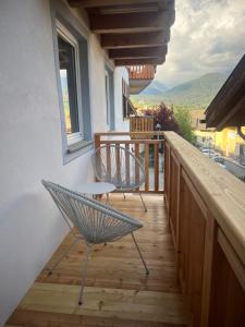 a balcony with two chairs and a table at Casa Lassù in Carano
