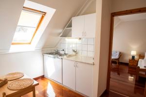 a kitchen with white cabinets and a window at Mooi Panzió in Nagyatád +52 photos