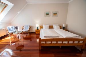 a bedroom with a large bed and two chairs at Mooi Panzió in Nagyatád