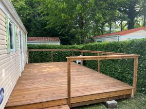 a wooden deck on the side of a house at Mobile home in Saint-Gérons