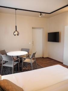 a living room with a table and chairs and a tv at Seepension Kakl in Velden am Wörthersee