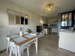 a living room with a table and a bedroom at Studio face mer L'escapade marine in Calais