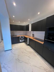 a kitchen with black cabinets and a marble floor at Maison 3 chambres in Strasbourg