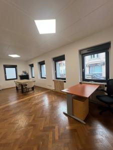 an empty room with a table and chairs and windows at Maison 3 chambres in Strasbourg +8 photos