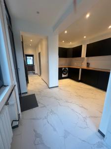 a large kitchen with a white tile floor at Maison 3 chambres in Strasbourg
