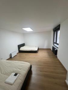 an empty room with two beds and a window at Maison 3 chambres in Strasbourg