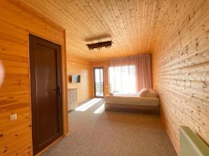 a bedroom with a bed in a wooden wall at SUNSET BUKNARI in Buknari