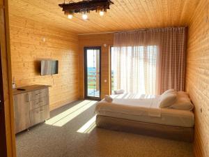 a bedroom with a large bed and a window at SUNSET BUKNARI in Buknari