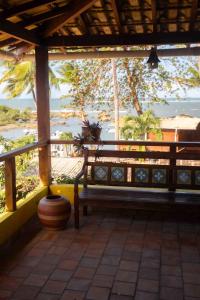 a porch with a bench and a view of the ocean at Pousada Funny in Morro de São Paulo +19 photos