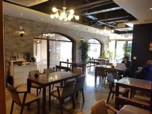 a restaurant with tables and chairs and people sitting at tables at 24 Guesthouse Suncheon in Suncheon