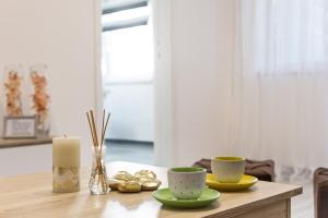 a table with two cups and a candle on it at S Apartman Vrdnik in Vrdnik
