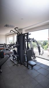 a gym with several treadmills and machines in a room at Los Olivos Hotel in San Estanislao