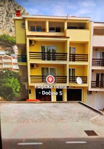 a yellow building with a sign in front of it at Bugenvilija in Duće +46 photos