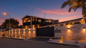 a house with a fence in front of a building at Royal Palms Guest House in Port Elizabeth