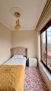 a bedroom with a bed and a large window at İsgobya Dağ Evleri 101 in Macka