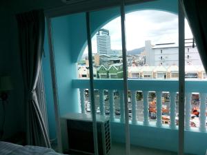 een slaapkamerraam met uitzicht op de stad bij The Duck in Phuket