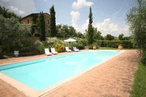 a large swimming pool with chairs and a house at L'Aquila e L'Ulivo in Montepulciano +28 photos