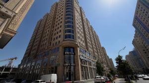 a tall building with a sign on the front of it at Zafran Platinum Apartments in Dushanbe