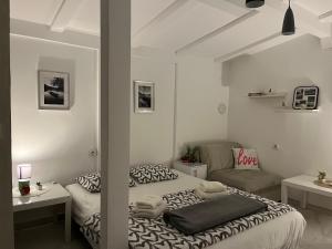 a white room with a bed and a couch at Vikendica Vilcek in Mali Zvornik