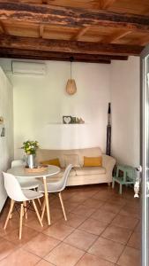 ein Wohnzimmer mit Sofa und Tisch in der Unterkunft Is Scabas Guestrooms in Solarussa