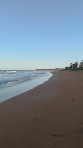 an empty beach with footprints in the sand at Refúgio da praia in Serra