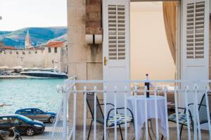 a table and chairs on a balcony with a view of the water at Vila Liza in Trogir