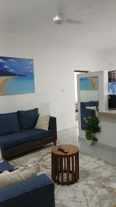 a living room with a blue couch and a table at Imani staycations Diani 2 in Diani Beach