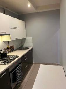 a kitchen with white cabinets and a stove top oven at Piter Piotr Bezpalko in Knurów