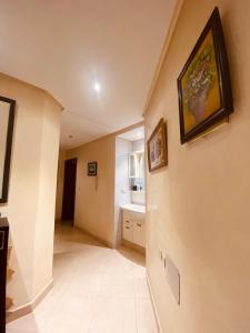 a hallway with a sink and a painting on the wall at Meknes Hamria centre ville only families and forneigners in Meknès
