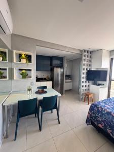a kitchen and living room with a table and chairs at STUDIO Mar azul 1206 in São Luís