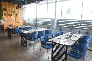 a dining room with tables and blue chairs at Grand Savera in Saharsa +16 photos