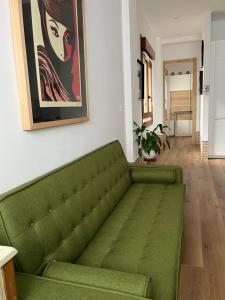 a green couch in a living room with a painting at Tentietxea in Areatza