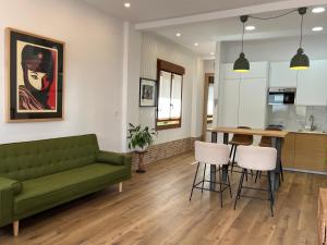 a living room with a green couch and a kitchen at Tentietxea in Areatza