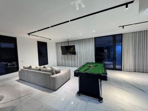 a living room with a couch and a pool table at Sky High 15 Choose Between 2 Luxury Penthouses in Beer Sheva