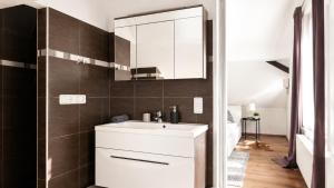 a bathroom with a white sink and a mirror at Haus OS in Bischofshofen +11 photos