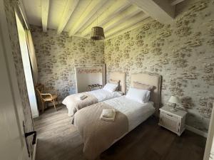 a bedroom with two beds and floral wallpaper at La Motte Feuilly in La Motte-Feuilly