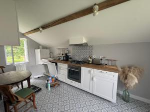 a kitchen with white cabinets and a stove top oven at La Motte Feuilly in La Motte-Feuilly