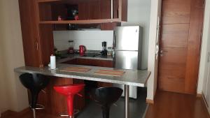 cocina con encimera con nevera y taburetes en Lima Flats 2, en Lima