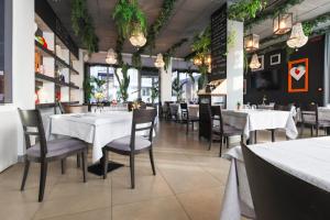 a dining room with white tables and chairs at Castelmartini Wellness & Business Hotel in Larciano