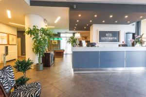 a lobby with a waiting area with plants and a counter at Castelmartini Wellness & Business Hotel in Larciano +75 photos