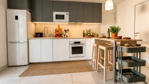 a kitchen with white cabinets and a white refrigerator at Lodge Marie in Villegailhenc