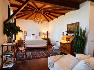 a bedroom with a bed and a chandelier at La Rayuela Suites Boutique in Frontera +118 photos