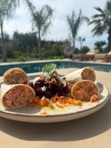 a plate of food on a table next to a pool at Villa Tonia Livadh Himare in Himare