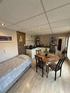 a bedroom with a bed and a table and a kitchen at departamento familiar 2 in Malargüe